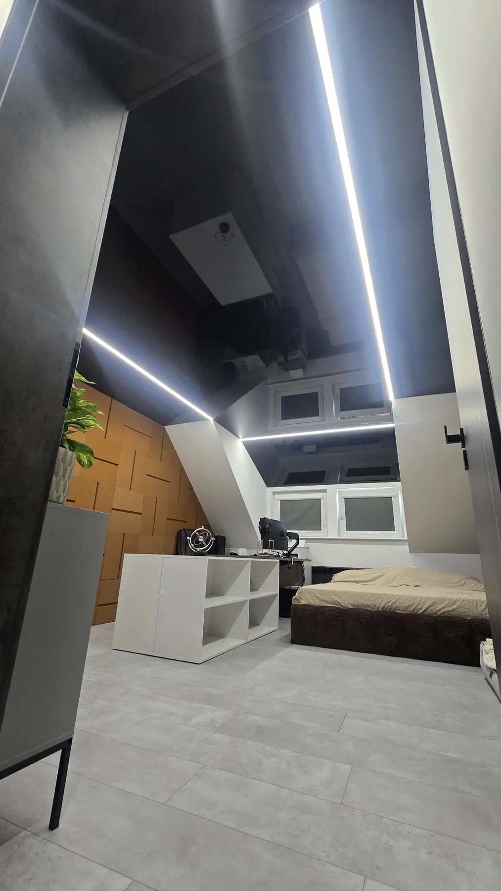 Czarny lustrzany sufit napinany z liniami LED na poddaszu