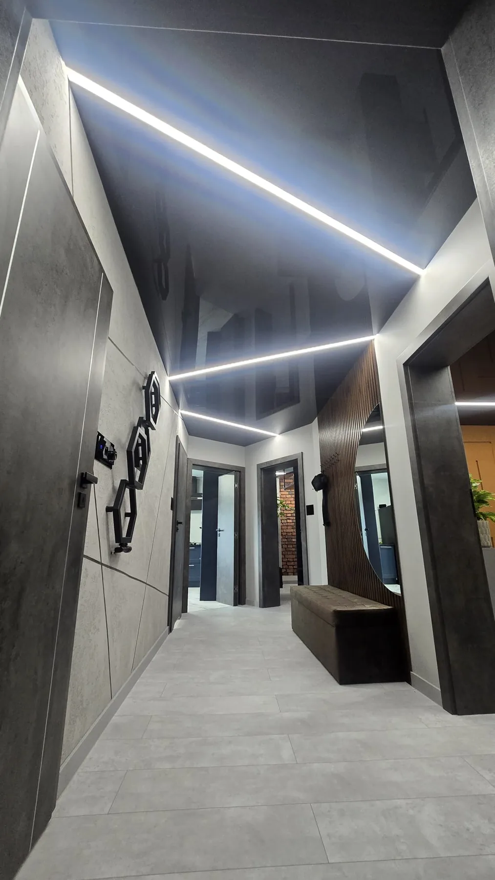 Czarny lustrzany sufit napinany z liniami LED w korytarzu